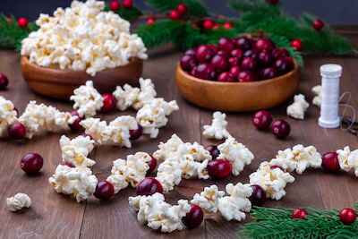 Popcorn and berries spread out on table to make popcorn garland